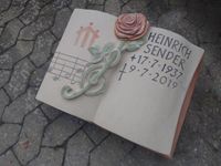 Buch aus Sandstein als Urnengrab mit Rose aus Sandstein auf dem Friedhof in Eltmann